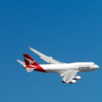 Qantas Boeing 747 captured mid-flight against a clear blue sky, symbolizing aviation and travel.