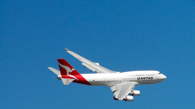 Qantas Boeing 747 captured mid-flight against a clear blue sky, symbolizing aviation and travel.